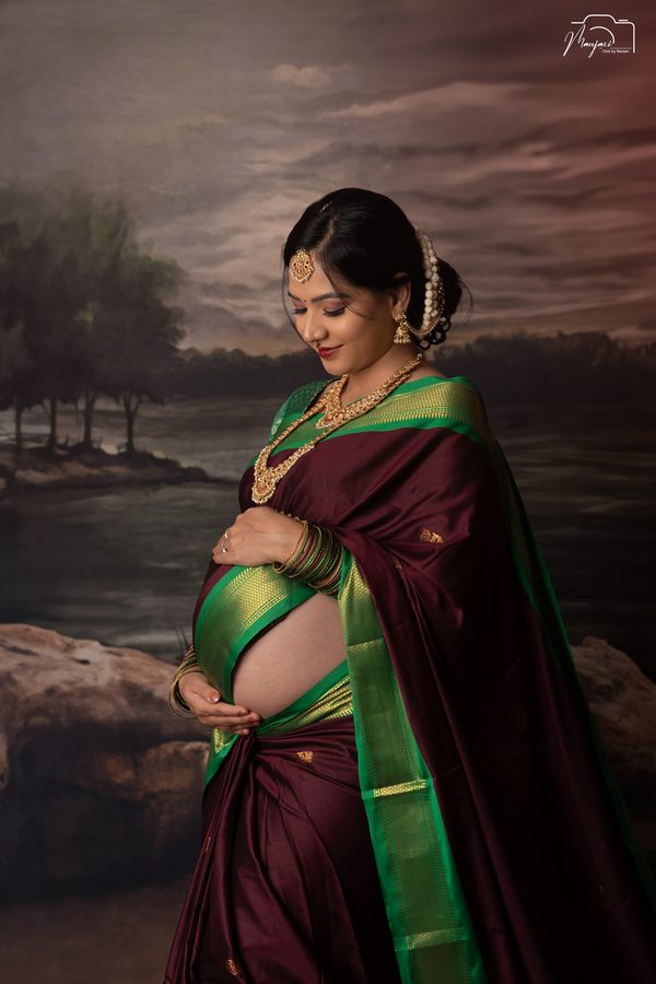 Traditional maternity portrait in a maroon and green silk saree