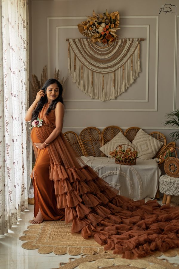 Expectant mother in a rust tiered gown on a warm boho set
