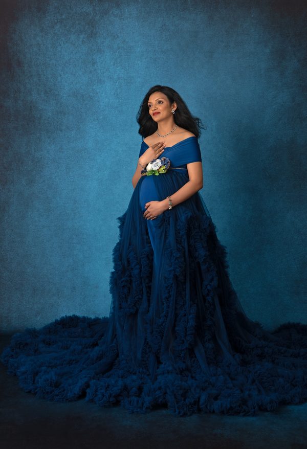 Expectant mother in a flowing royal blue gown