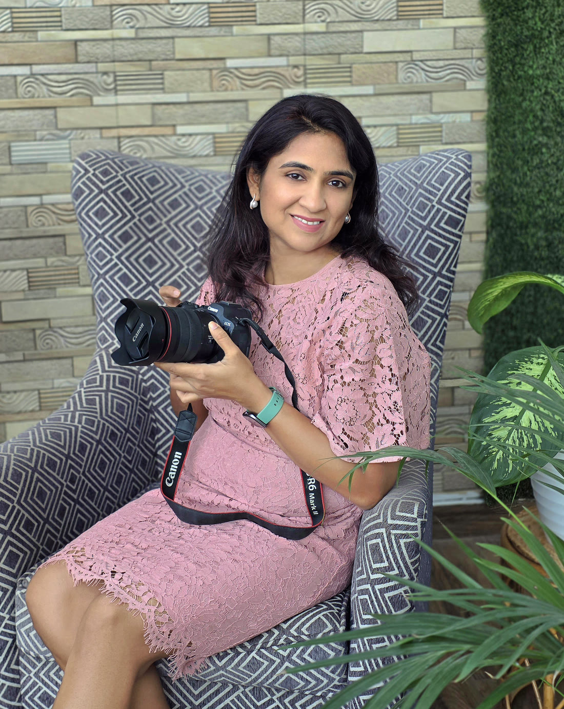 Manjari in a pink lace dress, holding her camera