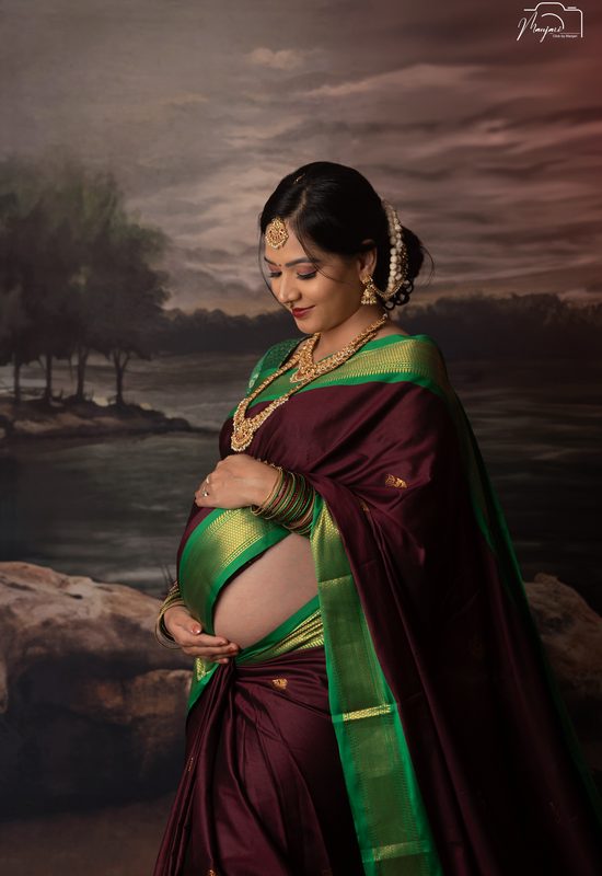 Traditional maternity portrait in a maroon and green silk saree