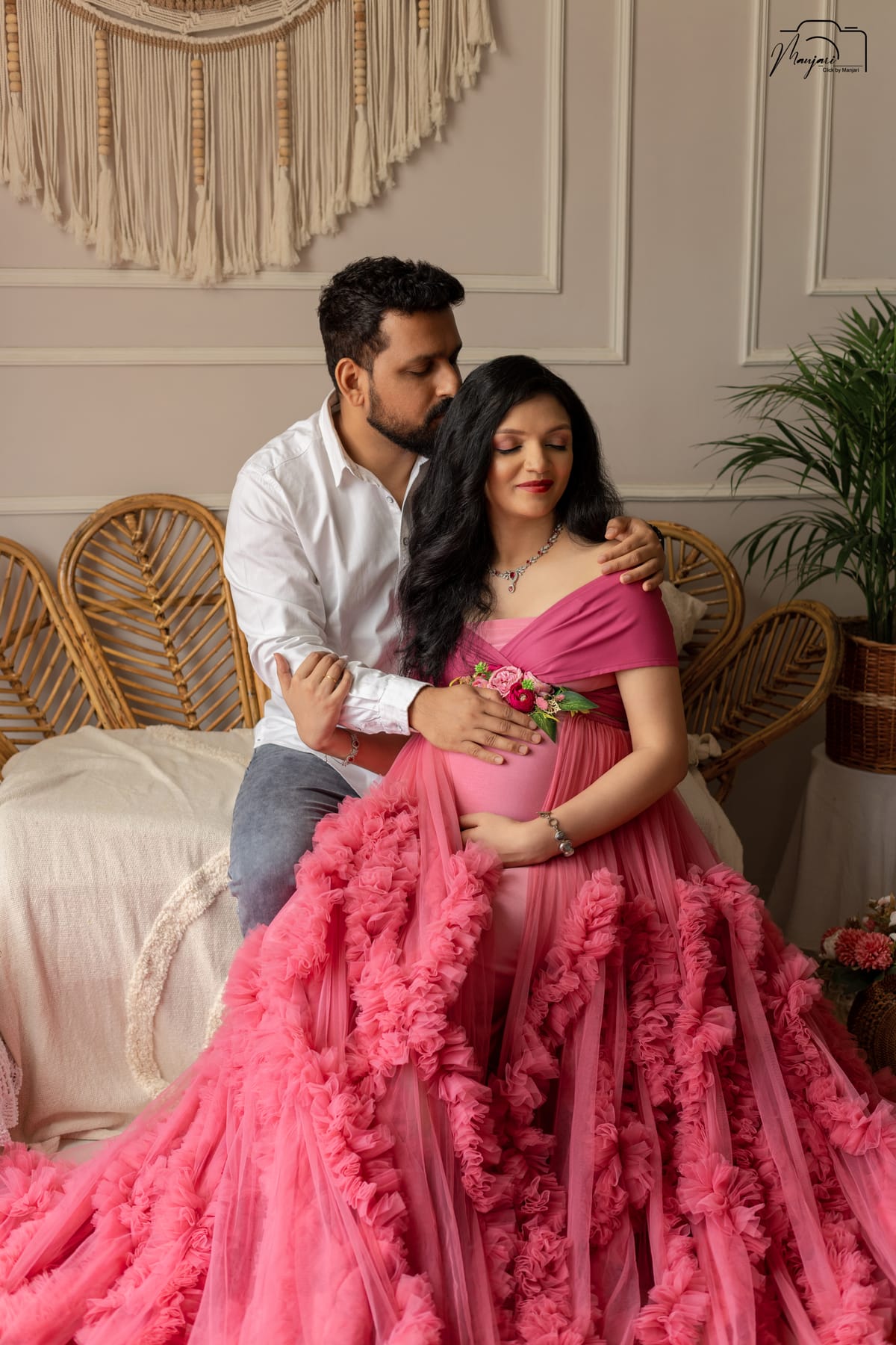 Couple maternity portrait in a flowing pink ruffled gown